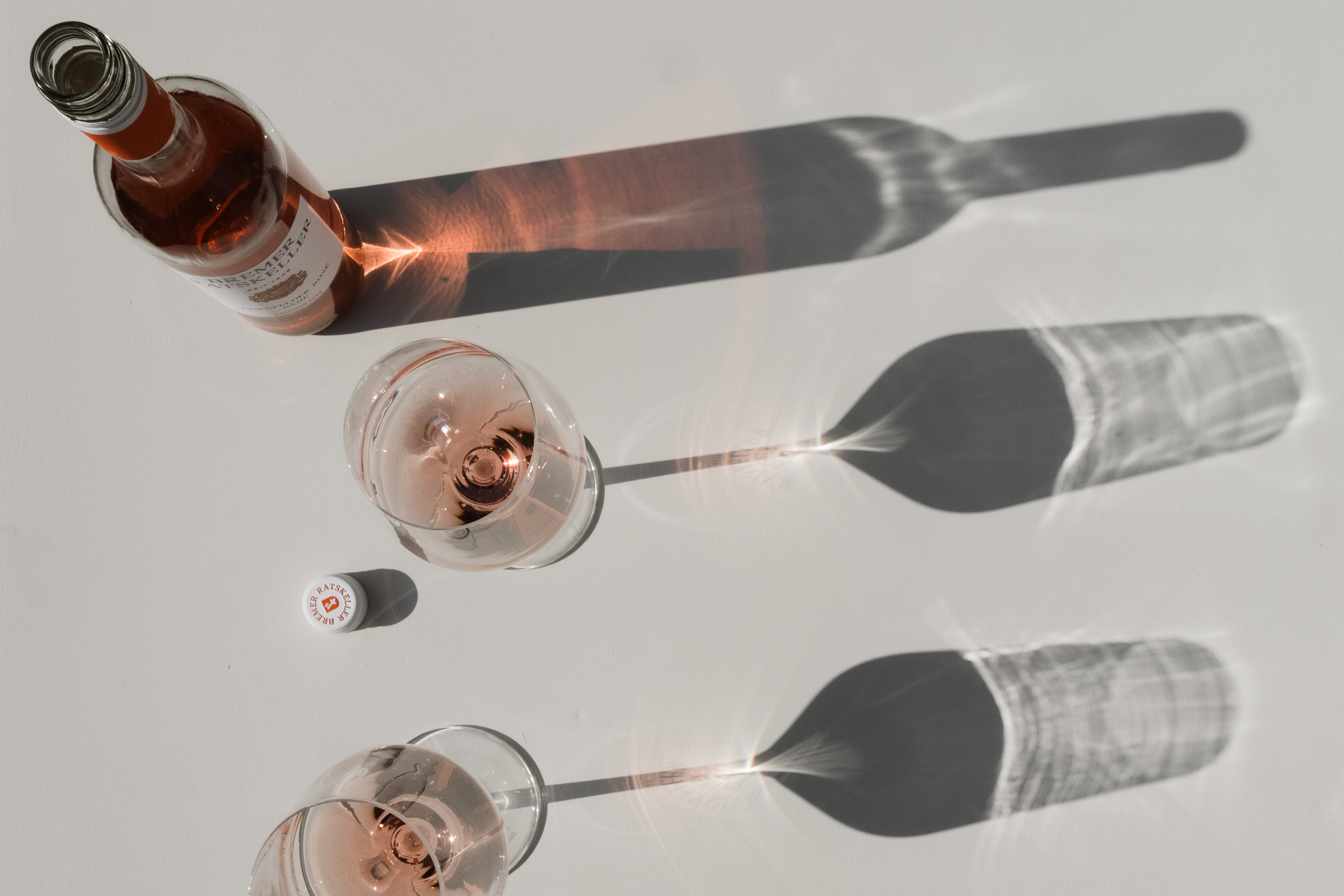 Roséwein Rosé Weinflaschen und Weingläser im Sonnenlicht