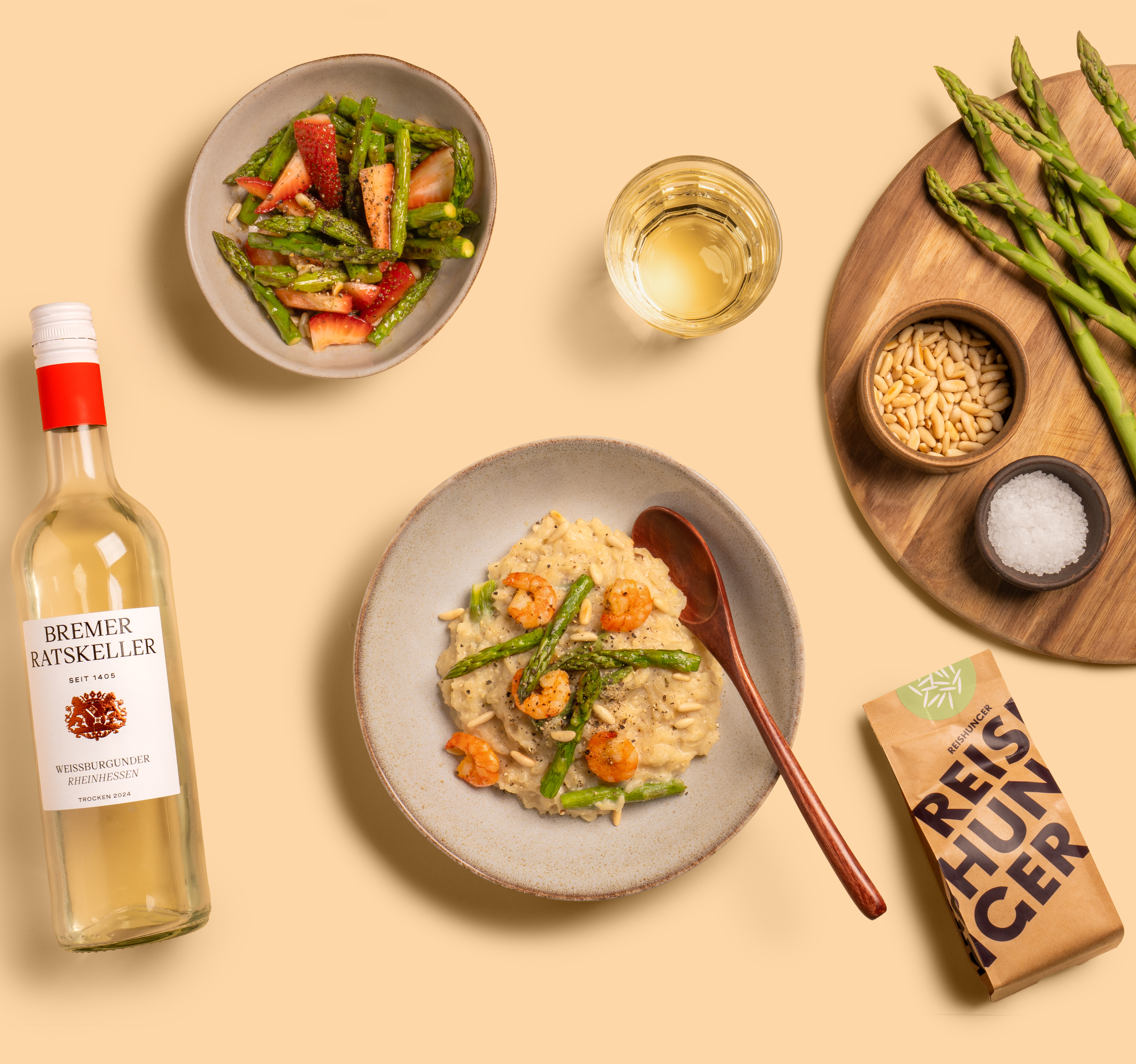 Spargelrisotto auf einem Teller mit Holzlöffel und einer Flasche Wein vom Bremer Ratskeller