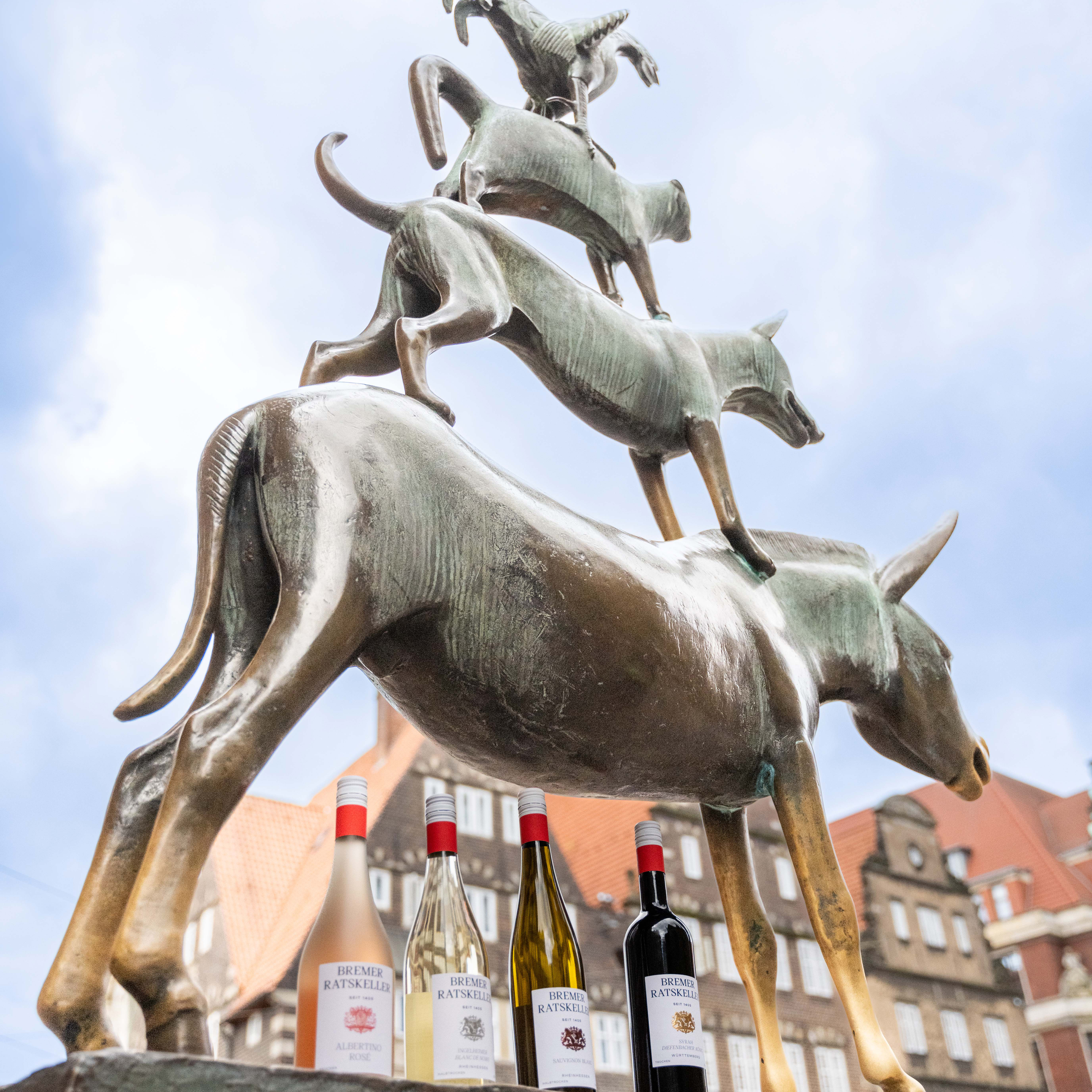 Flaschen vom Bremer Ratskeller stehen auf dem Sockel der Bremer Stadtmusikanten