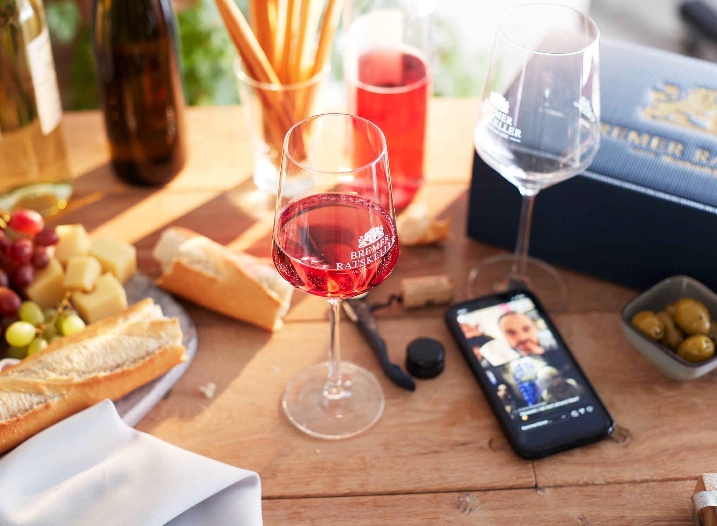 Kellerstunde Ein gedeckter Tisch mit einem Mobiltelefon auf dem gerade die aktuelle Kellerstunde des Bremer Ratskellers gezeigt wird